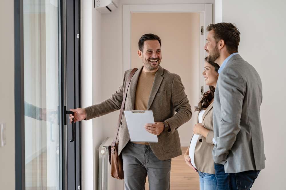 young couple with real estate agent being shown a home