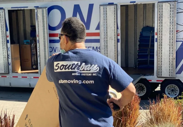 Southbay mover carrying a large box toward a moving truck