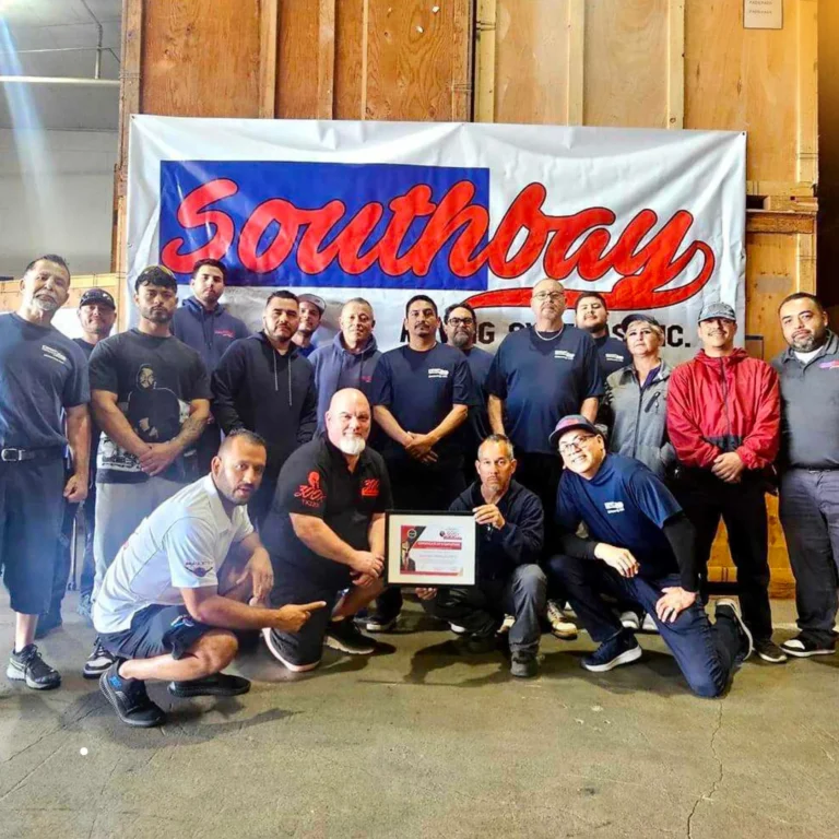 Southbay Moving Systems team in front of the Southbay banner at the warehouse
